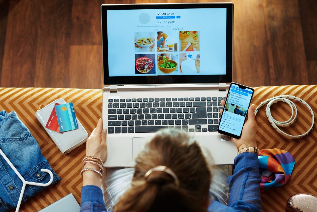 housewife browsing social media on laptop and smartphone